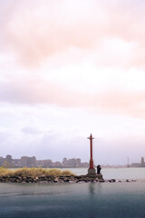 lighthouse on the coast with people fishing