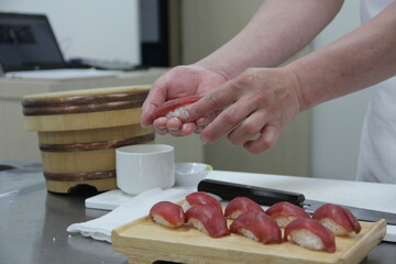 Professional sushi chef hand preparing sashimi to make perfect sushi with precision and confidence.