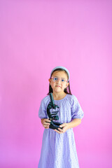 Pretty little girl holding a compound microscope in her hands.