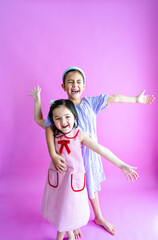 Two pretty little girls standing while reaching out wide and laughing.