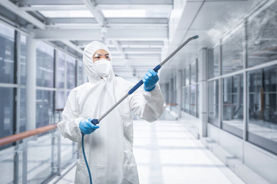 Worker wears medical protective suit or coverall suit sanitize with spray