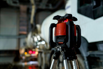 Laser level on a tripod at the construction site of an industrial building