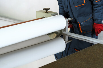 The master uses an industrial roll laminator. Applying a protective film to a stainless steel sheet