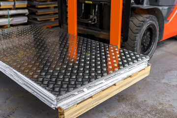 Forklift loader in the metal warehouse. Loading and unloading stainless steel sheets