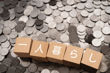 一人暮らしと書かれたブロックとコイン
