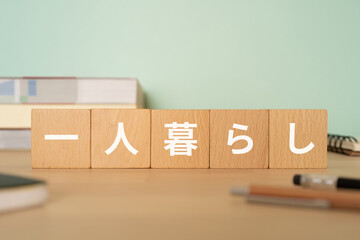 一人暮らしと書かれたブロックが置かれたデスク
