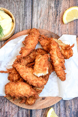 
 Crispy  deep fried   Chicken strips and wedges potato. Breaded  with cornflakes chicken  Breast fillets  with chilly peppers and fresh   basil on wooden rustic background