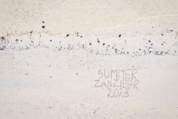 A sunny preview of your upcoming Zanzibar getaway in the summer of 2023 - captured in this gorgeous photo of the beach and a handwritten message in the sand.