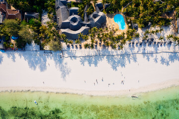 Indulge in a luxurious getaway at Zanzibar's Kiwengwa beach, where the white sand, turquoise waters, and palm trees create a serene and refreshing atmosphere for a truly memorable vacation.