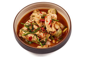 Creamy Tom Yum Kung Soup placed on a blue tablecloth, That is a very popular dish in Thailand, containing of vegetables and herbs such as chili, lemongrass, lime leaves, lime and mushrooms.