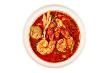 Top view of Creamy Tom Yum Kung Soup, That is a very popular dish in Thailand, containing of vegetables and herbs such as chili, lemongrass, lime leaves, lime and mushrooms.