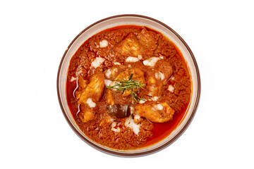Top view of Panang pork curry with coconut milk and sliced kaffir lime leaves in a bowl isolated on white background, Panang curry is a very popular Thai dish.