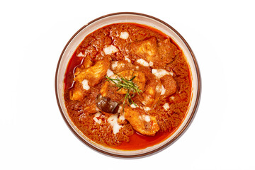 Top view of Panang pork curry with coconut milk and sliced kaffir lime leaves in a bowl isolated on white background, Panang curry is a very popular Thai dish.