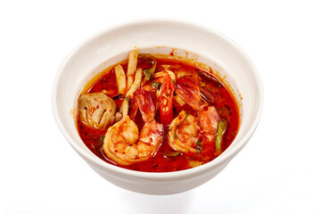 Top view of Creamy Tom Yum Kung Soup, That is a very popular dish in Thailand, containing of vegetables and herbs such as chili, lemongrass, lime leaves, lime and mushrooms.