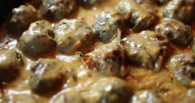 Delicious homemade swedish meatballs with creamy white sauce in frying pan