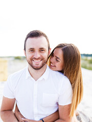 Fototapeta premium man and a woman are hugging on a sandy beach in summer