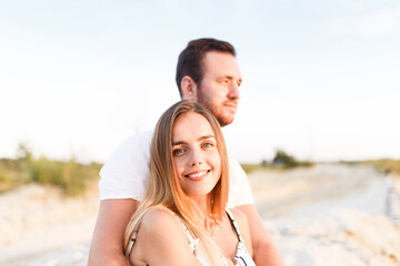 Fototapeta premium man and a woman in light clothes are laughing together on the beach
