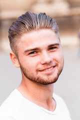 Fototapeta premium Young bearded blond man in a t-shirt on the street of the summer city