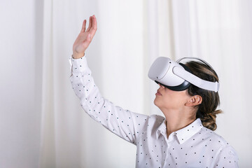 Young woman testing VR glasses or goggles sitting in the room.
