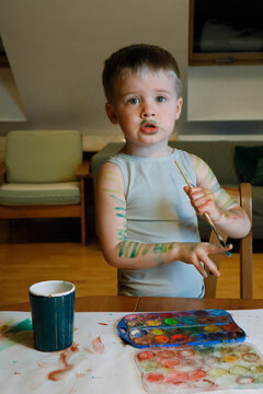 The child paints his hands with paint