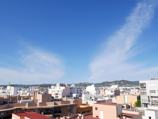 Fototapeta na wymiar Blue sky, white buildings and sun in Ibiza town