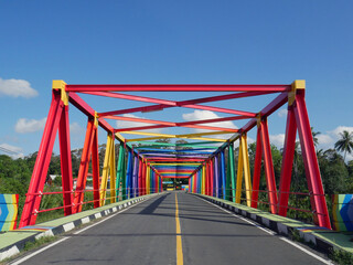 Fototapeta na wymiar Colorful bridge in the middle of the rainforest in Indonesia