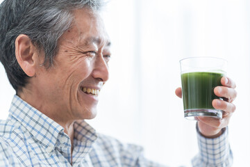 青汁を持つミドルの日本人男性