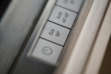 Close-up of eco button in a modern dishwasher control panel. Eco-friendly and energy-efficient...