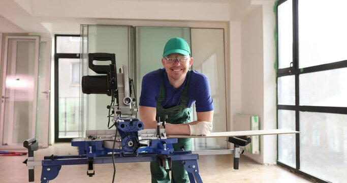 Smiling craftsman with laminator cutting machine
