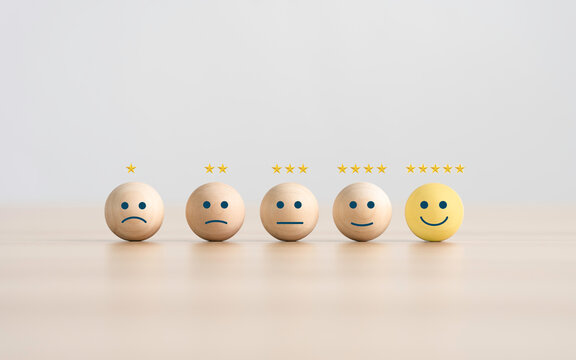 the happy face smile face icon on a wooden cube for Customer service evaluation customer satisfaction level and satisfaction survey concepts.