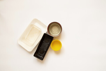 Various plastic and canned jars and old packages lie on a white background, food containers on a white
