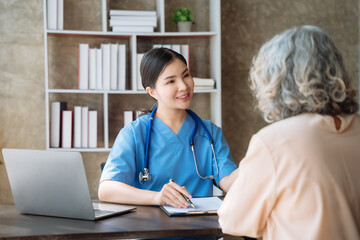 Female doctor consulting senior old patient filling form at consultation, talking to senior old patient filling signing medical paper at appointment visit in clinic.