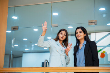Two indian Corporate woman talking each other some subject at office