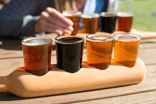 Beer samplers sit on a picnic table.