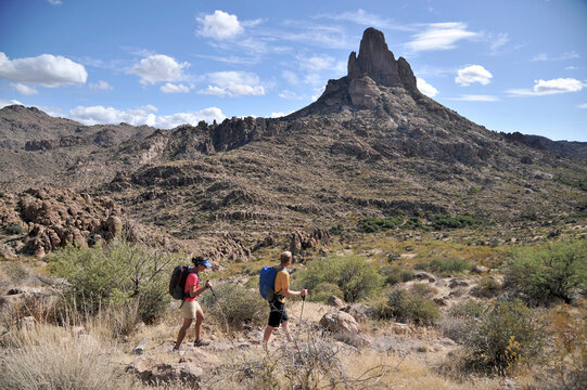 Man and woman backpackers hike on the popular Peralta Trail in the Superstition Wilderness Area, Tonto National Forest near Phoenix, Arizona November 2011.