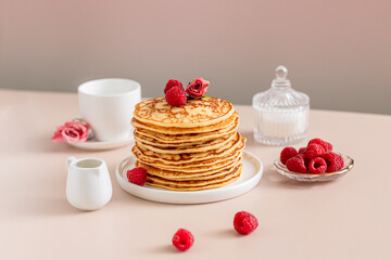 Modern breakfast. Plate with Pancakes with raspberries and cup of tea. 