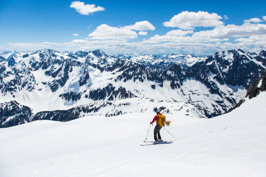 Man skiing down slope of Sahale Peak, North Cascades National Park, Washington State, USA