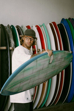 Man choosing a surfboard in a surfboard shop