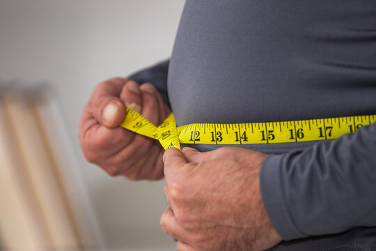 man with tape measure around his belly