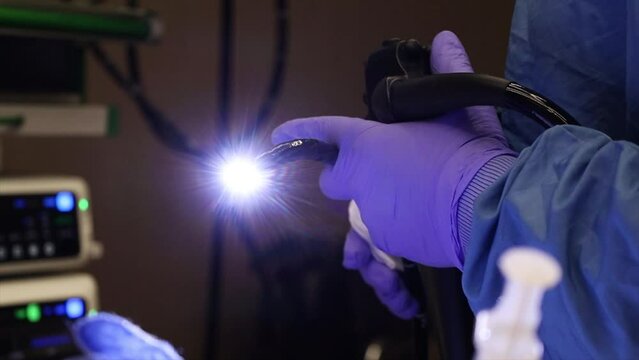 4K Close-up of the endoscope while operating stock video. Moment during the endoscopy operation. Close-up of endoscopy device in doctor's hand during operation.
