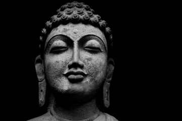 Fototapeta na wymiar Buddha Face Statue Isolated On Black Background, Granite Buddha Statue Portrait.