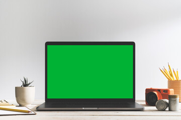 Chroma key green screen laptop on table with photography equipment