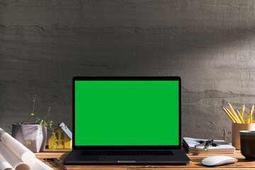 Chroma key green screen laptop on table with architectural equipment