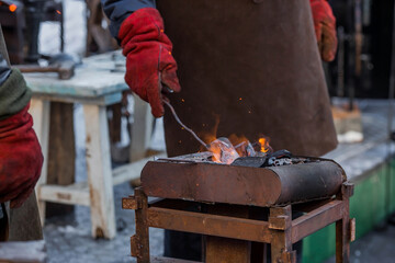 Moscow seasons. Traditional craft. The work of a blacksmith with metal at the celebration of Maslenitsa (Maslenitsa Week). Russian traditions. Tverskaya Street. Moscow. Russia