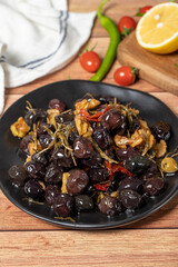 Mixed olives. Dried tomatoes, thyme, rosemary, walnuts and olives on the plate. Mediterranean flavors