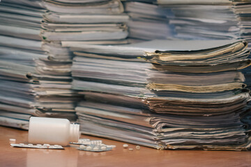 Workplace. Many documents, contracts, legal agreements, papers on work table and soothing pills. Focus on medications on workplace. Stressful about work, fatigue concept. Doping for stressful working