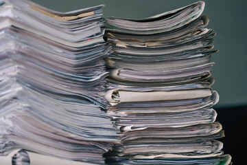 Stack of blank papers with binder clips on wooden table indoors. Workplace. Many documents, contracts, legal agreements, papers on work table. Concept of business, working, job.