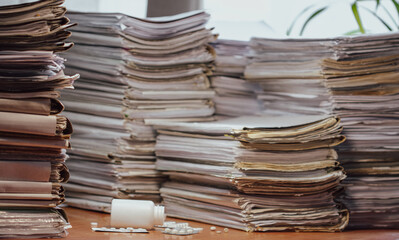 Stressful about work, fatigue concept. Doping for stressful working. Many documents, contracts, legal agreements, papers on work table and soothing pills. Focus on medications on workplace