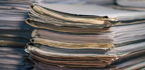 Stack of blank papers with binder clips on wooden table indoors. Workplace. Many documents, contracts, legal agreements, papers on work table. Concept of business, working, job.