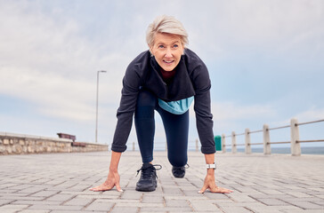 Senior woman, starting position and running outdoor at beach promenade, runner exercise or sky mockup. Elderly lady ready to run, cardio and fitness training for mindset of sports, marathon or energy